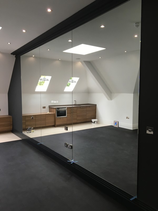 Frameless glass partition in loft conversion by Nine Elms glaziers